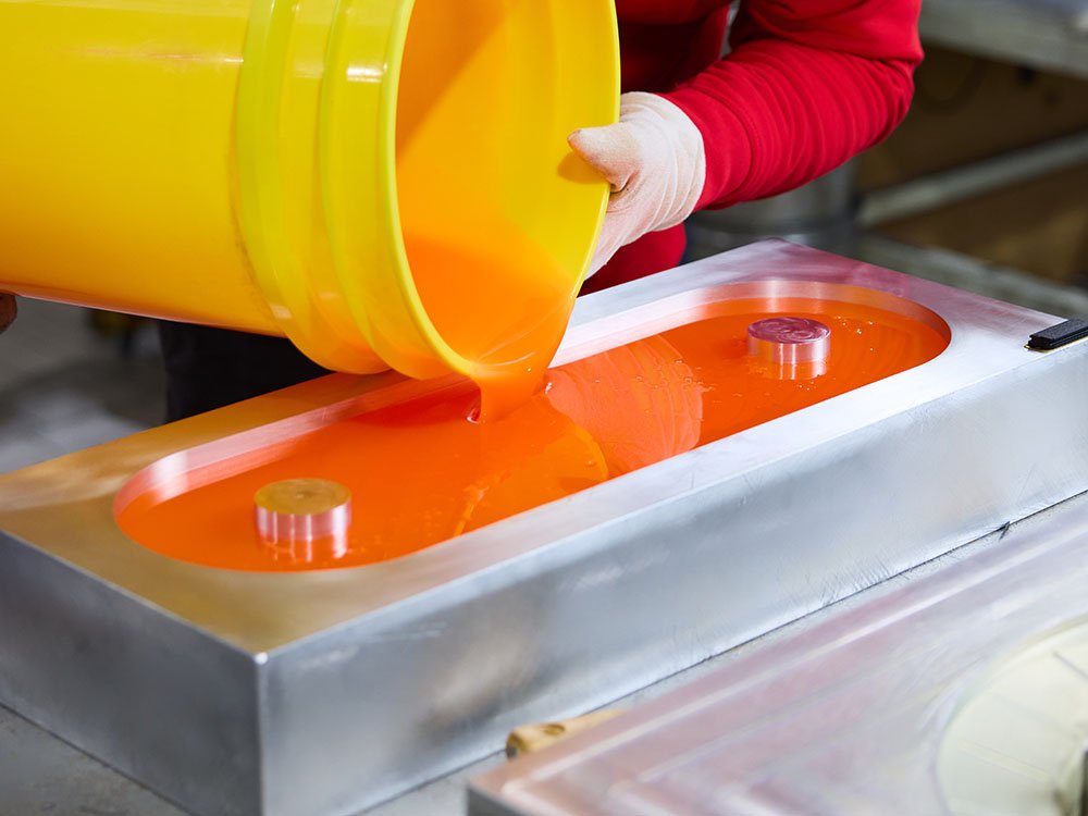 Gieß-Elastomer Verarbeitung bei der Herstellung von Polyurethan-Formteilen Flüssiges Polyurethan wird in eine rechteckige Metallform gegossen